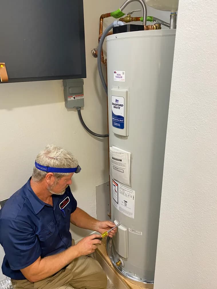 All Calls Plumbing technician installing a water heater