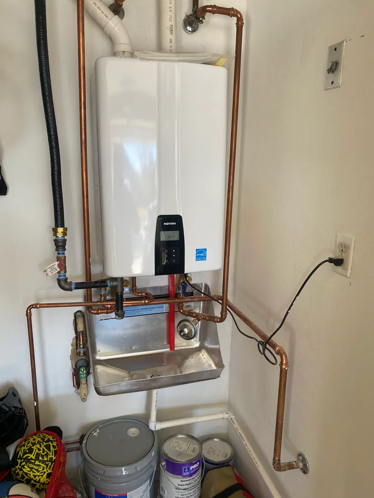 Navien tankless water heater installed with copper piping and utility sink